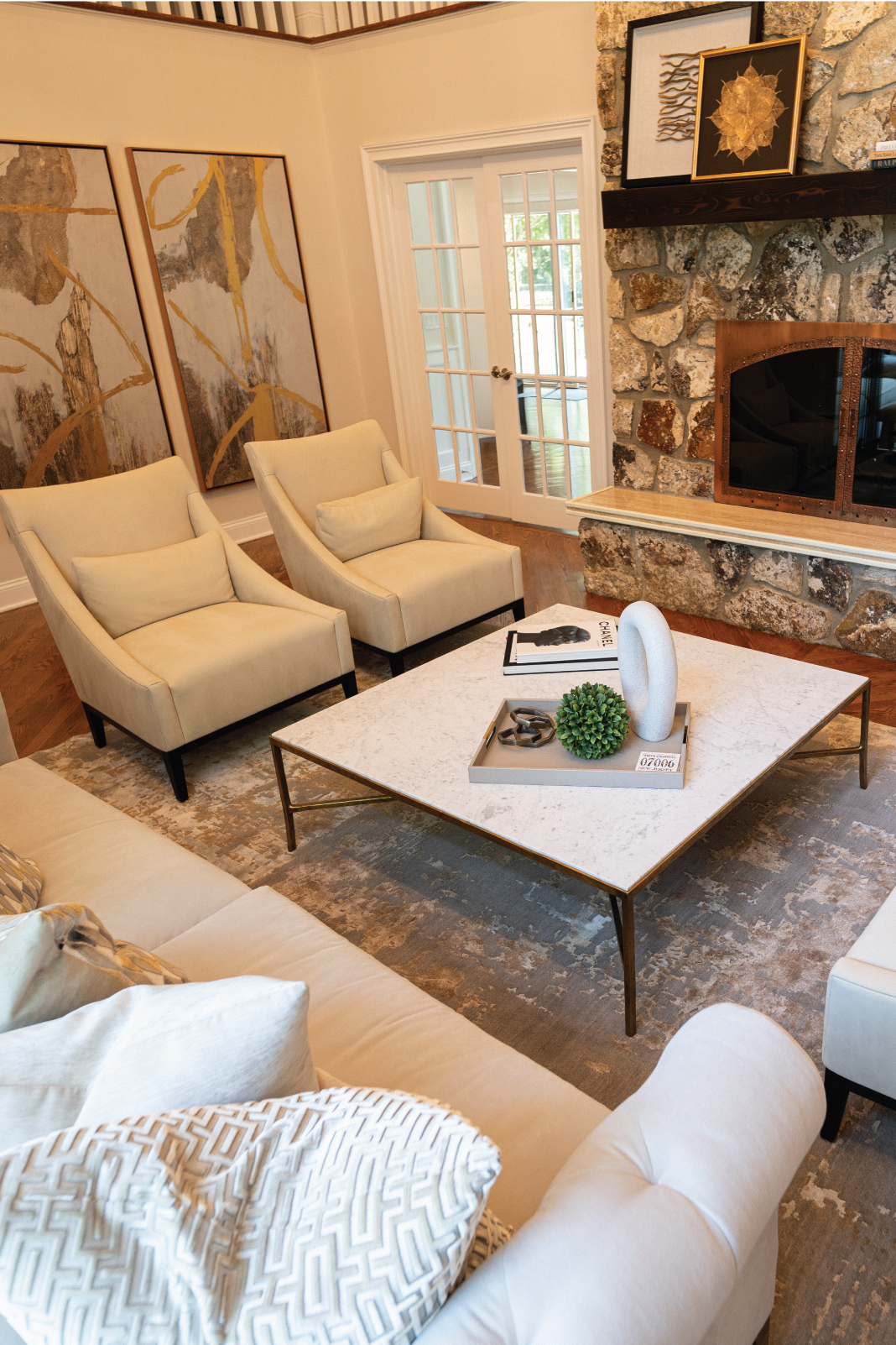 Traditional living room renovation in North Caldwell, New Jersey, featuring a preserved stone fireplace, warm neutral palette, velvet seating, and timeless residential interior design.