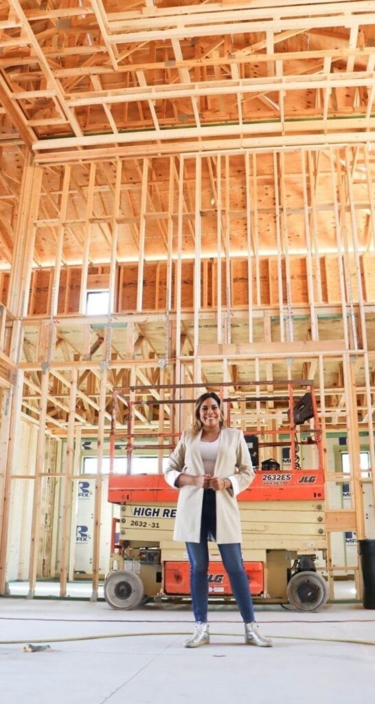 Zamira Ariza inside the framed double-height great room during the construction phase of Flaava House in Lady Lake, Florida.