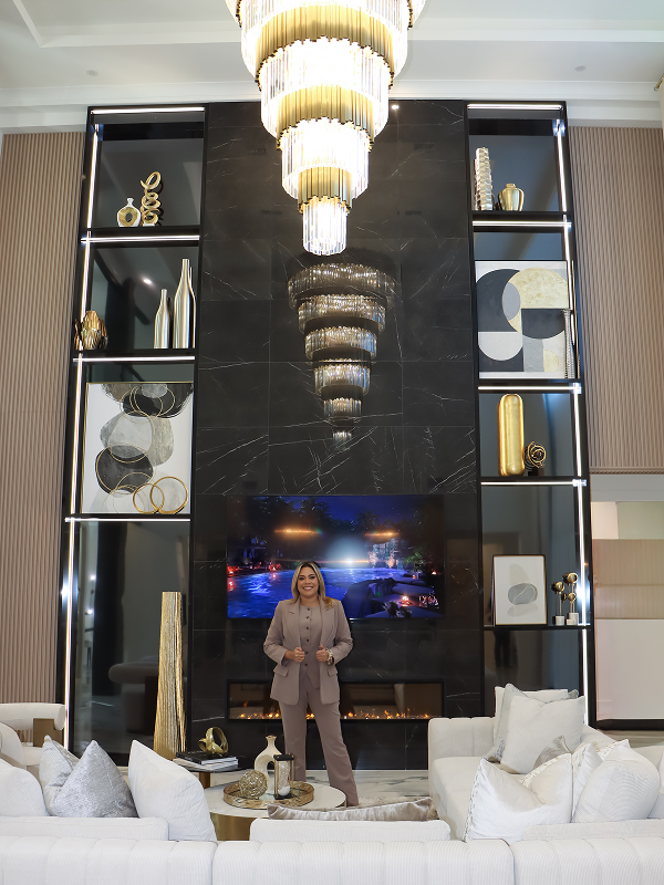 Luxury living room interior design in Lady Lake, Florida, showcasing a dramatic statement chandelier, black marble walls, white seating, and warm gold accents in a high-end home.