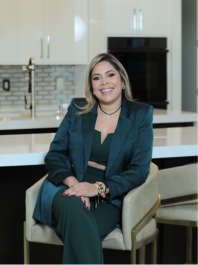 Zamira Ariza seated at the custom kitchen island inside Flaava House showcasing the completed contemporary kitchen design.