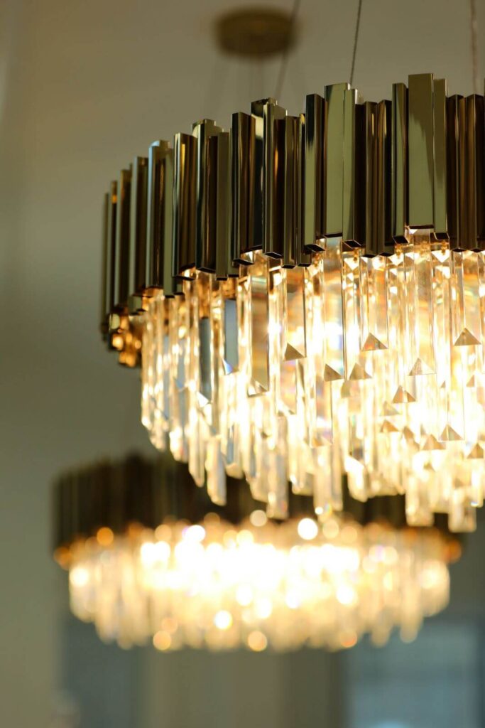 Close-up of a custom crystal chandelier with brushed gold detailing featured in the luxury living room at Flaava House.