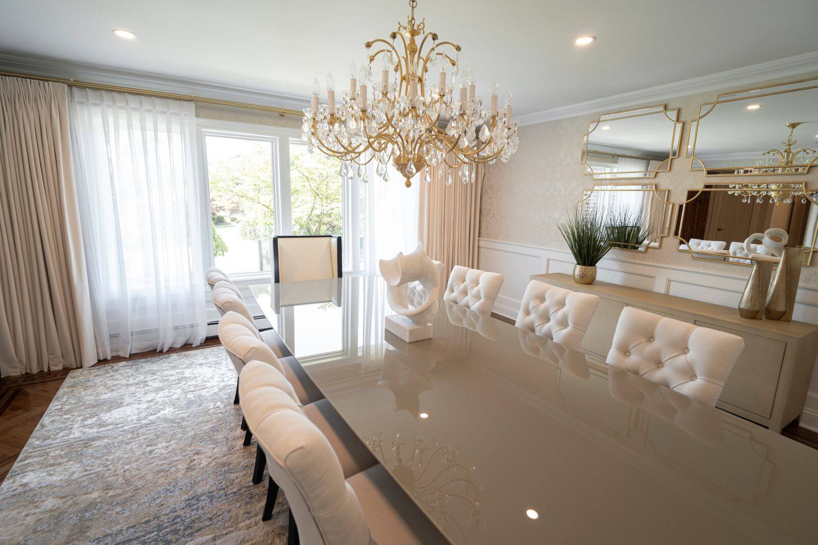 Elegant formal dining room with crystal chandelier, upholstered dining chairs, designer mirrors, custom buffet, and refined neutral finishes in North Caldwell, New Jersey.