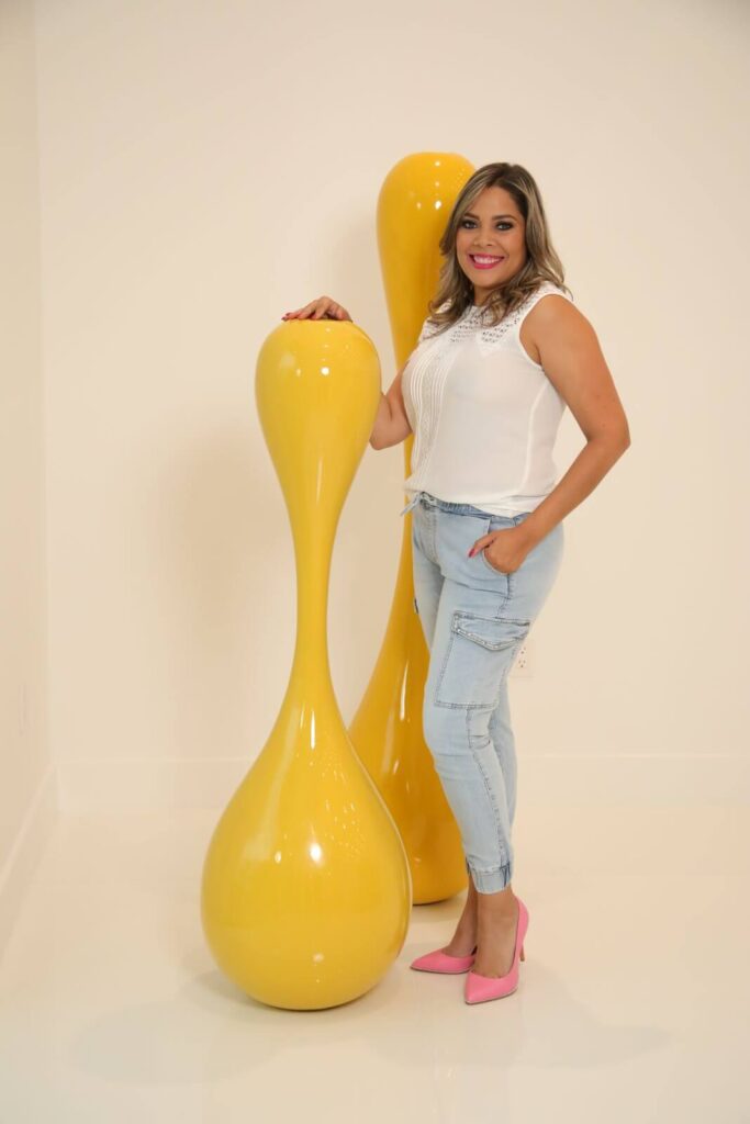 Interior designer Zamira Ariza beside contemporary sculptural artwork inside Canvas Sur luxury residence in Windermere, Florida.