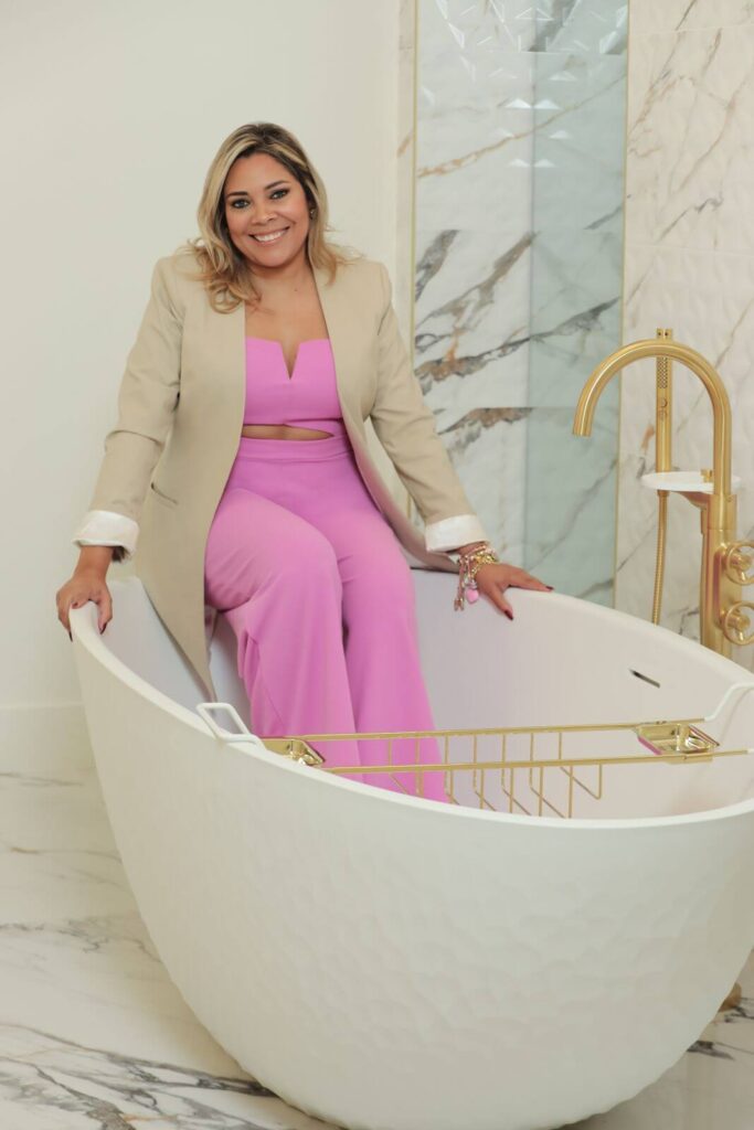 Freestanding soaking tub with gold fixtures in a luxury spa-inspired primary bathroom designed by Zamira Ariza.