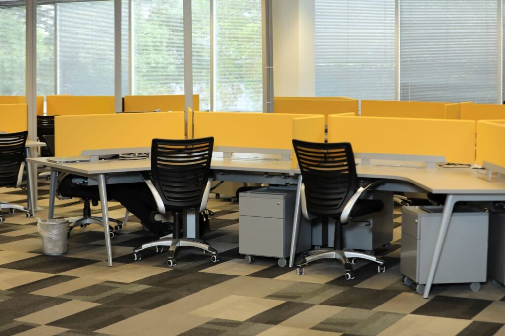 Open-plan corporate office with modern workstations, ergonomic task chairs, privacy panels, and collaborative workspace design in Westwood, Florida.